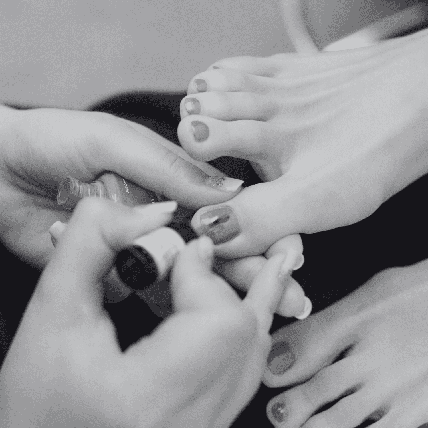 Person receiving a pedicure with red nail polish being applied to toenails.